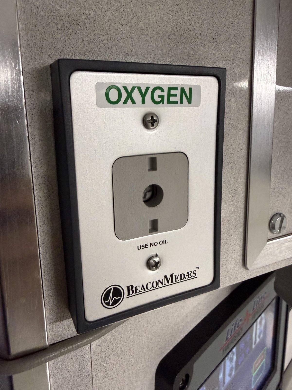 Oxygen wall outlet mounted on the patient compartment wall of an ambulance